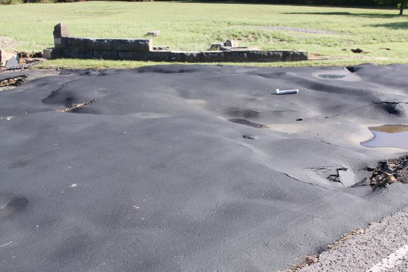Sinkholes, bumps and cracks appeared in a road from flood damage in May 2010.